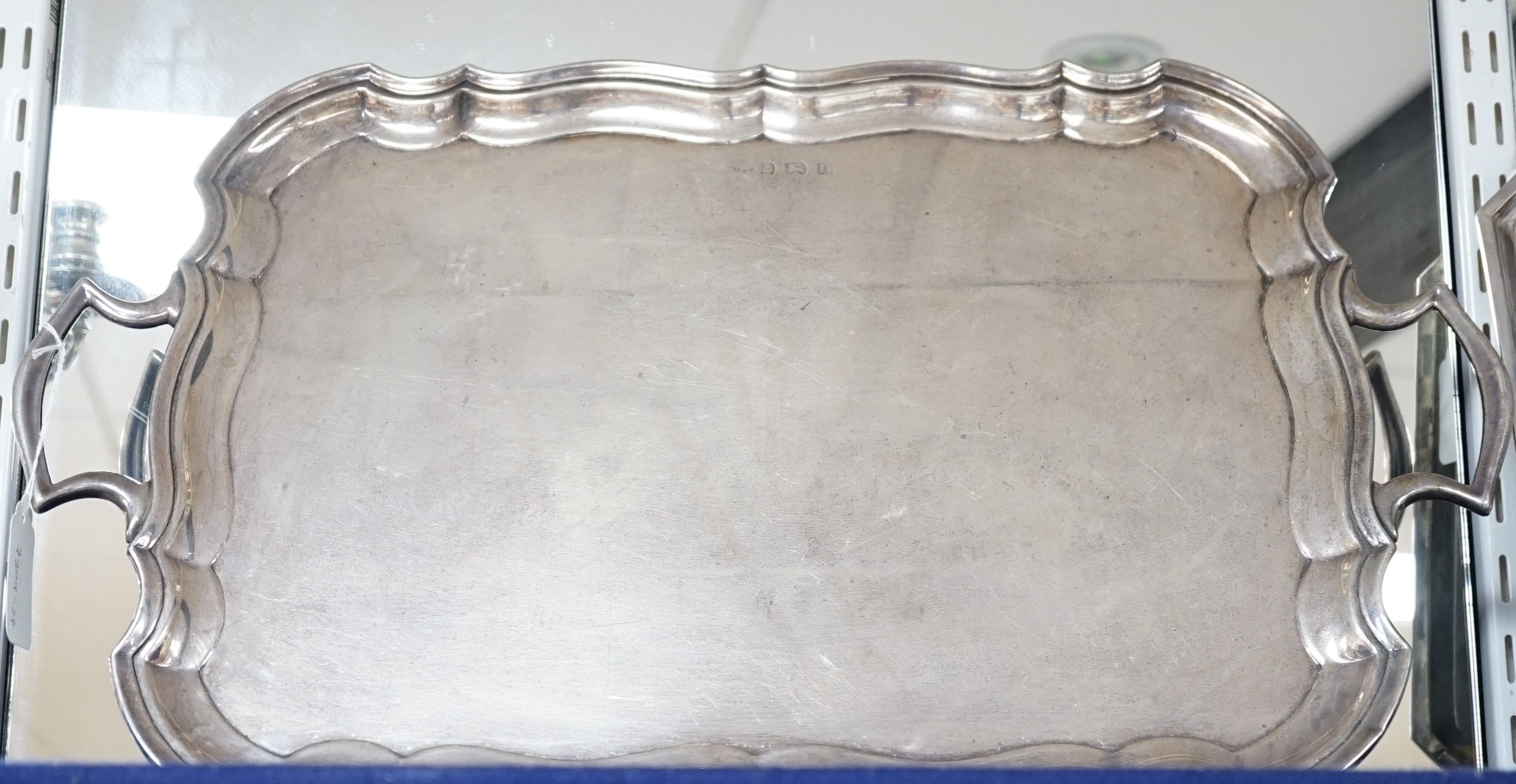 A George V silver two handled tea tray, with wavy border, Joseph Gloster Ltd, Birmingham, 1928, 56.3cm over handles, 70.5oz.